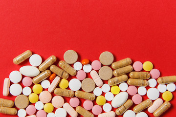 Medication white colorful round tablets arranged abstract on red color background. Aspirin, capsule pills for design. Health, treatment, choice healthy lifestyle concept. Copy space for advertisement.