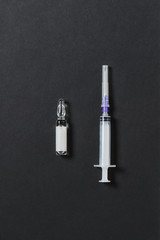 Naklejka premium Medication ampoule, empty syringe needle on black background. Health, treatment, choice, healthy lifestyle concept. Copy space for advertisement. With place for text.
