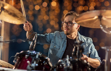 male musician playing drums and cymbals at concert