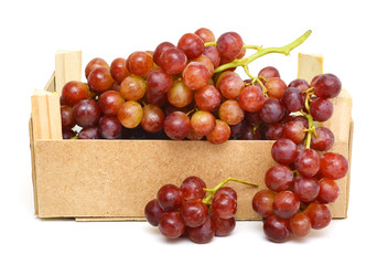 red grapes isolated in wooden crate on white