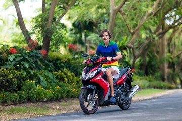 Fototapeta na wymiar Teenager riding scooter. Boy on motorcycle.