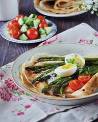 Breakfast of pancakes baked with asparagus with boiled egg and cream cheese