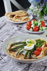 Breakfast of pancakes baked with asparagus with boiled egg and cream cheese