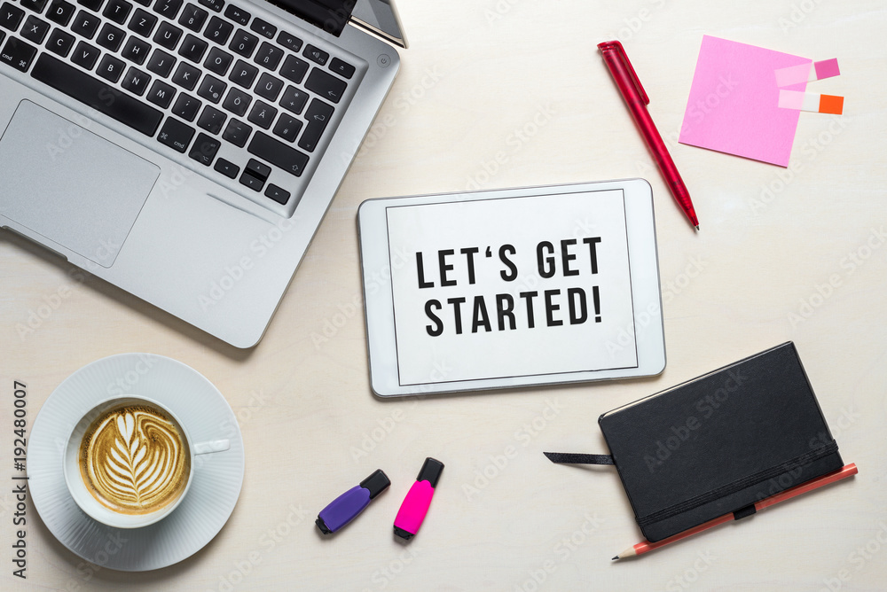 Wall mural let's get started written on tablet lying on desk as flatlay