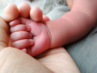 Mother Holding hand of infant showing love and care