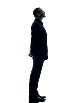one caucasian business man standing profile silhouette isolated on white background