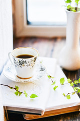 open book, coffee mug by the window, the concept of dreams and thoughtfulness