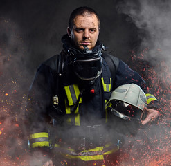 A firefighter dressed in a uniform in a studio.