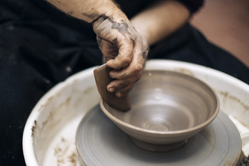 Fototapeta na wymiar Artist makes clay pottery on a spin wheel