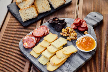 A set of various cheeses, smoked sausage, apricot orange sauce, walnuts, blood sausage and fried...