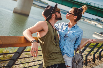 Fototapeta premium Urban couple going for a kiss by the river