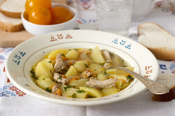 Stew or roast or soup with meat and potatoes, served with canned tomatoes and bread.