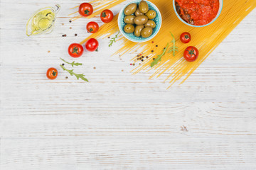 Ingredients for preparation pasta spaghetti - tomato, olive oil, spices, herbs, green olives, tomato sauce
