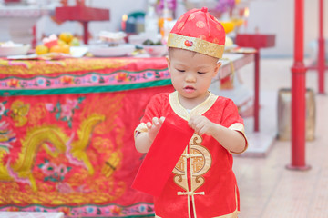 Cute little Asian 18 months / 1 year old toddler baby boy child in red Chinese suit holding &...