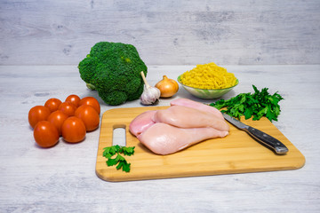 Ingredients for cooking pasta with chicken and broccoli lying on the table