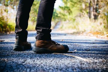 Young man standing in the middle of a divided highway in the wilderness.