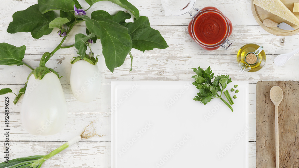 Wall mural top view food white eggplants with flowers and cutting board, tomato sauce, cheese, parmesan and spring onion on kitchen wooden table, template and copy space