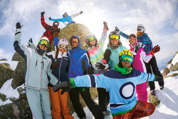 Fototapeta na wymiar Group of friends snowboarders having fun on the top of mountain