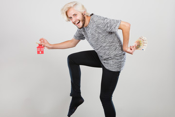 Man holding money and keys to house