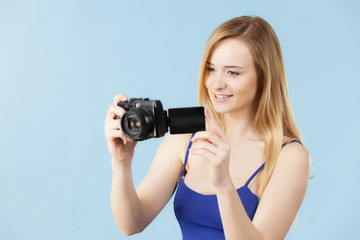 Blonde woman with camera on blue