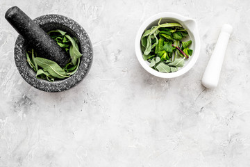Phytotherapy. Herbs in mortar bowl on white background top view copy space