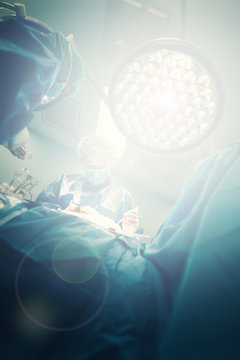 Team of surgeons in hospital operating room with surgery lightning ready for cardiovascular emergency surgery interventions with clamps, forceps, electrocautery and technology equipment for open heart