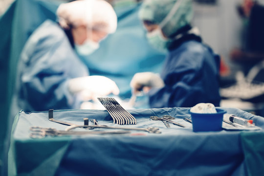 Medical team of surgeons in hospital doing minimal invasive surgical interventions. Surgery operating room with electrocautery equipment for cardiovascular emergency surgery center.