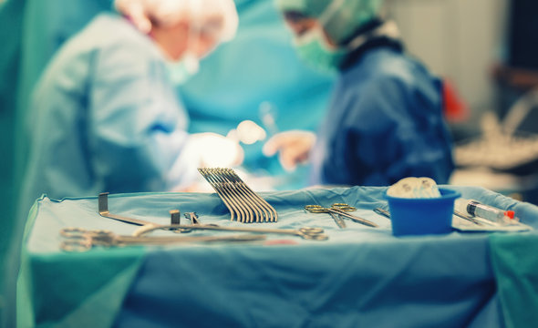 Medical team of surgeons in hospital doing minimal invasive surgical interventions. Surgery operating room with electrocautery equipment for cardiovascular emergency surgery center.
