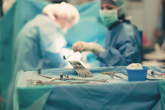 Team of surgeons in hospital operating room. Ready for cardiovascular emergency surgery interventions with clamps, forceps, electrocautery and all technology equipment for open heart microsurgery