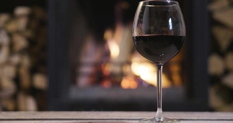 In winter, before the fireplace, is poured, tasted red wine in a glass. Concept of: relax, restaurant, wine, somelier.