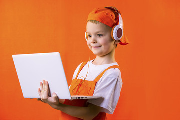 funny boy builder in headphones and laptop doing repairs on bright background