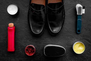 Clean shoes. Set of shoe care products. Polish, brushes, wax, sponge. Black background top view
