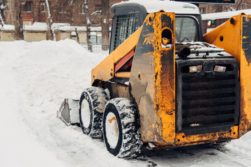 the snowplow stands on the street during the day