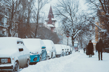 cars are parked along the roads covered in snow