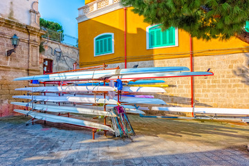 Fototapeta na wymiar Racing rowing boats standing on metal stand at Monopoli old port.