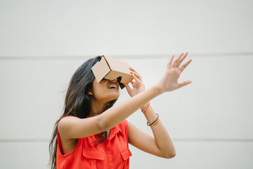 A young Indian Asian woman tries VR (Virtual Reality) goggles for the first time and is surprised...