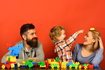 Parents and kid in playroom. Parenthood and game concept