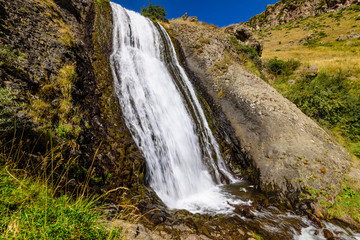 Fototapeta na wymiar Artsci waterfall - a beautiful waterfall and natural landmark near Stepantsminda (Kazbegi) village, Caucasus mountains, Georgia