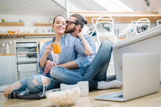 Young couple watching movie on laptop at home 