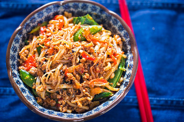 Sichuan spicy pork noodles with bean sprouts, sugar snap peas and oak choi