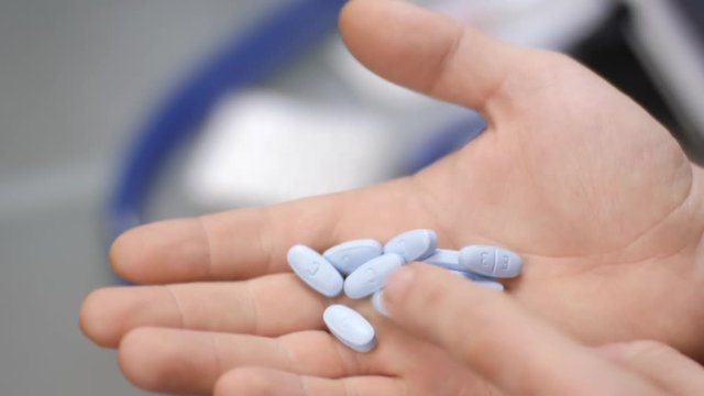A man pours pills into his hand