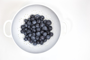 Organic blueberries in a white collander