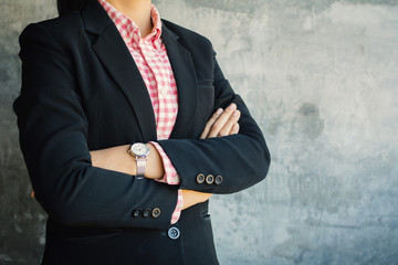 Obraz na płótnie Canvas Businesswoman cross one's arm standing with confident on loft background
