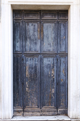 Isolated old door in gray and blue colors. Ancient door in the white wall