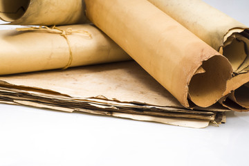 Scrolls of parchment on a background of sheets of old parchment on a white background