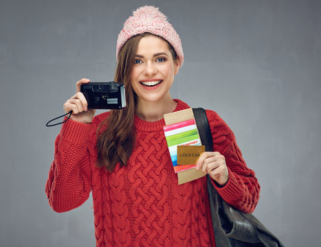 Happy woman dressed red knitted sweater holding camera, credit c