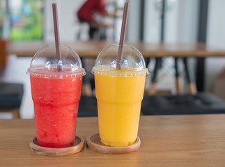 Sweet yellow mango with water melon smoothie on wood table in coffee shop