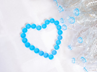 Empty plastic bottles of water for recycle with heart shape from bottle cap on white background