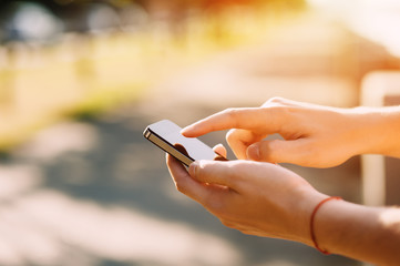 	 Man using mobile smartphone in the hands on the sunset background	
