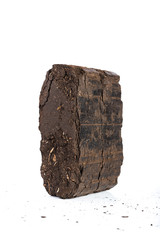 Peat briquette on white background, alternative fuels, raw material